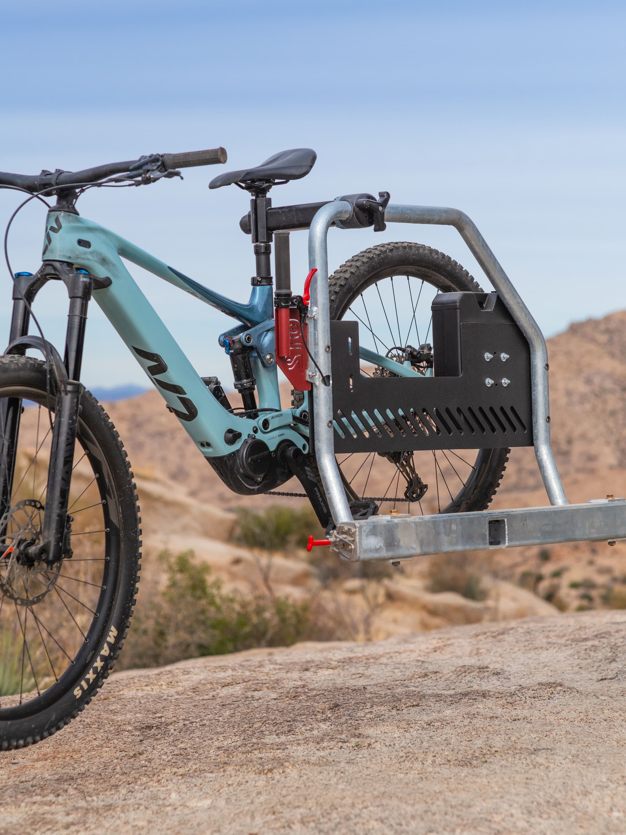 Side view of blue mountain bike attached to Escapod TOPO2 MTB trailer using integrated bike rack.