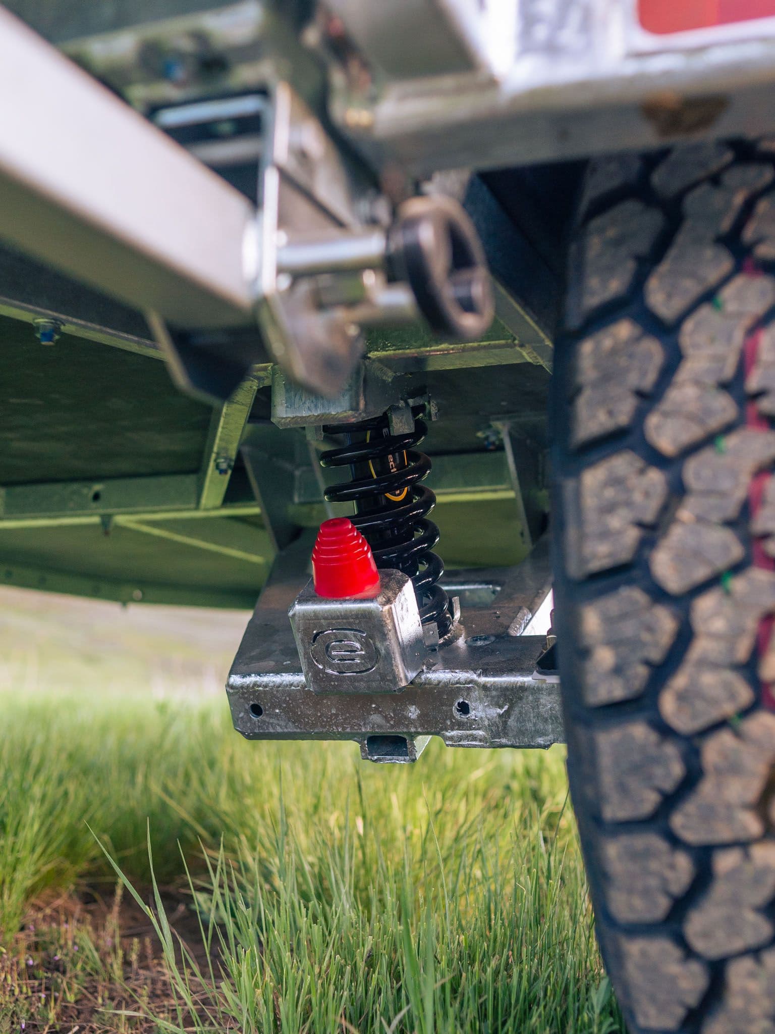 Close-up of the FREERIDE Suspension System on an Escapod TOPO2 trailer, showing its durable shock-in-spring off-road setup.